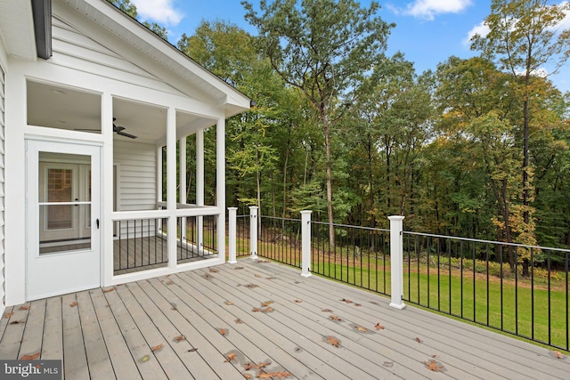 deck with a lawn and ceiling fan