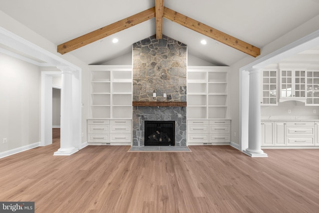 unfurnished living room with light hardwood / wood-style flooring, a stone fireplace, and lofted ceiling with beams