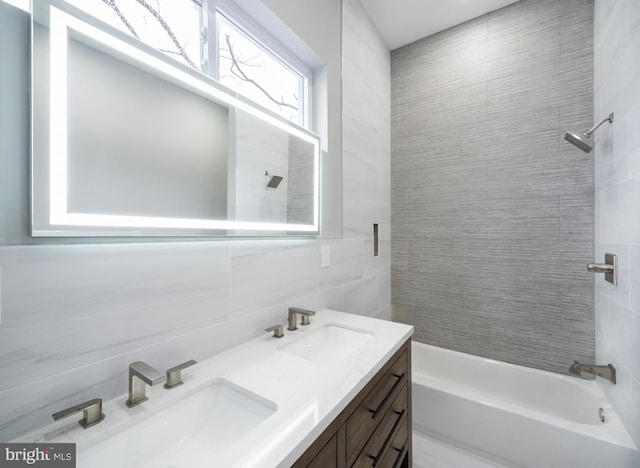 bathroom featuring decorative backsplash, tiled shower / bath combo, vanity, and tile walls