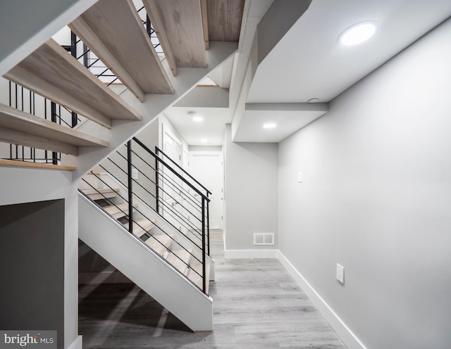 staircase with hardwood / wood-style floors