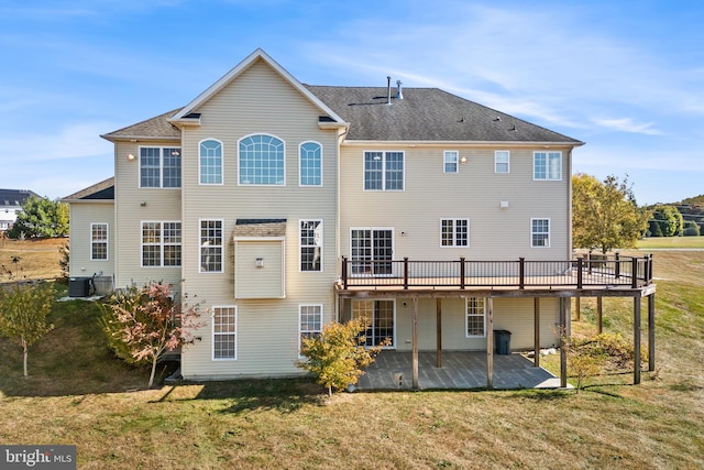 back of property featuring central AC, a deck, and a lawn