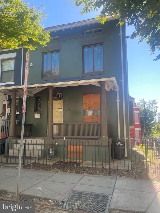 518 Columbia Rd NW, Washington, DC 20001 - townhome / multi-family property with a porch, stucco siding, a fenced front yard, and a gate