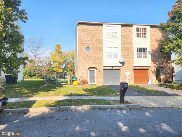 multi unit property with a front yard, brick siding, driveway, and an attached garage