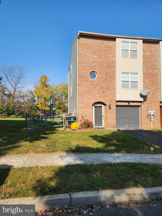 view of front of property with a garage, brick siding, a front lawn, and aphalt driveway