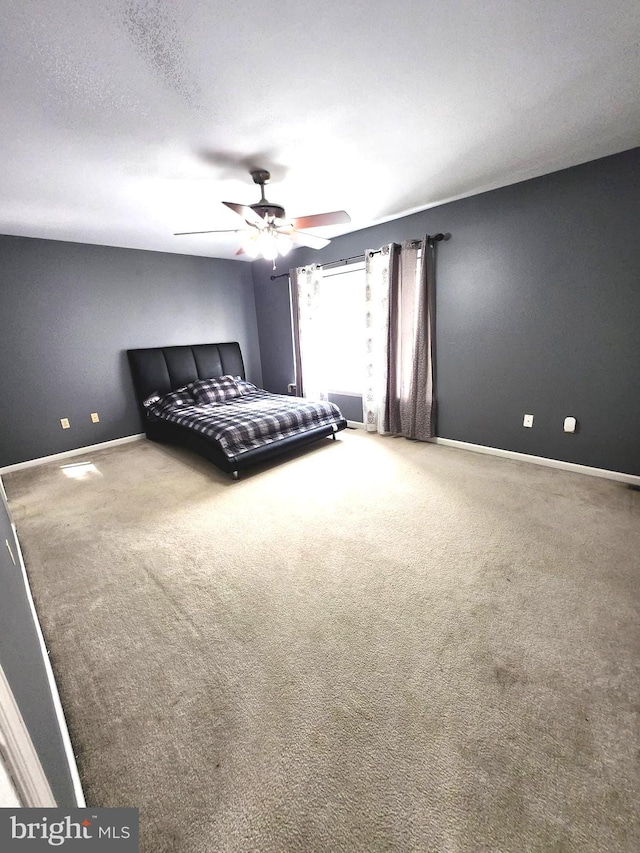 unfurnished bedroom with ceiling fan, carpet floors, and a textured ceiling