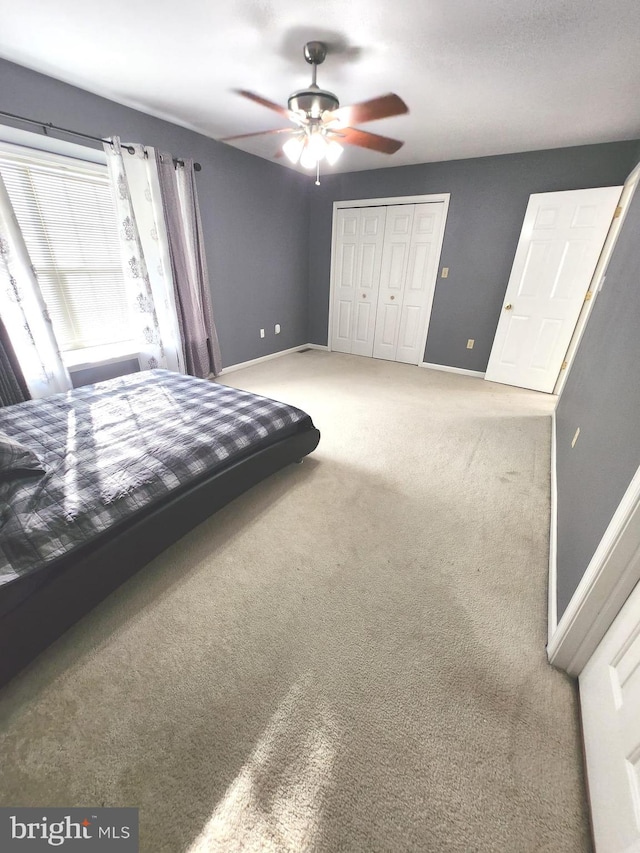 unfurnished bedroom featuring ceiling fan, a closet, and carpet flooring