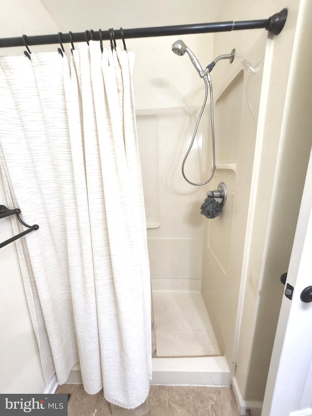 bathroom with tile patterned flooring and walk in shower