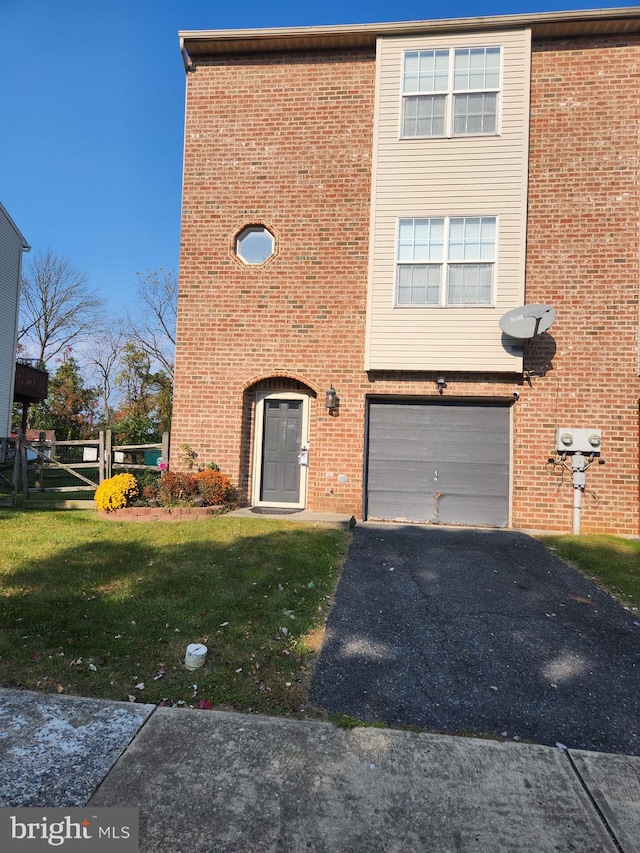 view of front of home with an attached garage, driveway, a front lawn, and brick siding