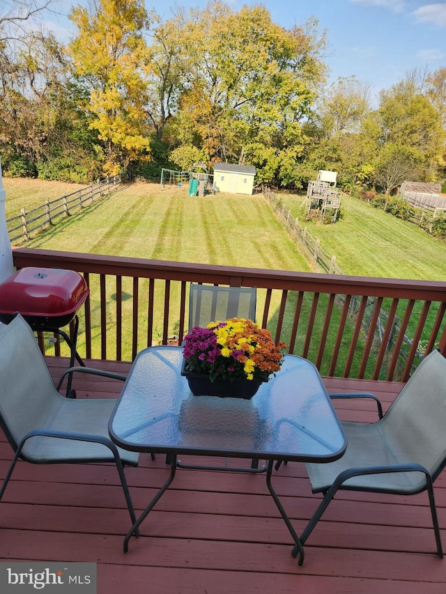 wooden deck featuring a yard and a storage unit