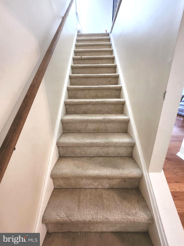 stairs featuring hardwood / wood-style floors