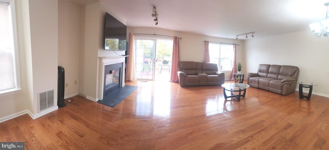 living room featuring hardwood / wood-style floors, track lighting, and a chandelier