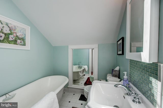 bathroom with tasteful backsplash, sink, a bath, toilet, and lofted ceiling