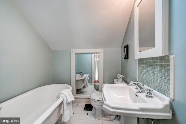 bathroom with lofted ceiling, backsplash, sink, toilet, and a tub