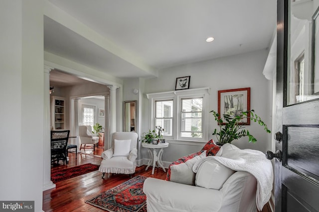 living room with hardwood / wood-style flooring and decorative columns