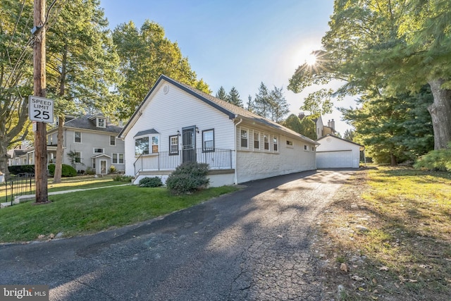 view of front of home with a garage, an outdoor structure, and a front yard