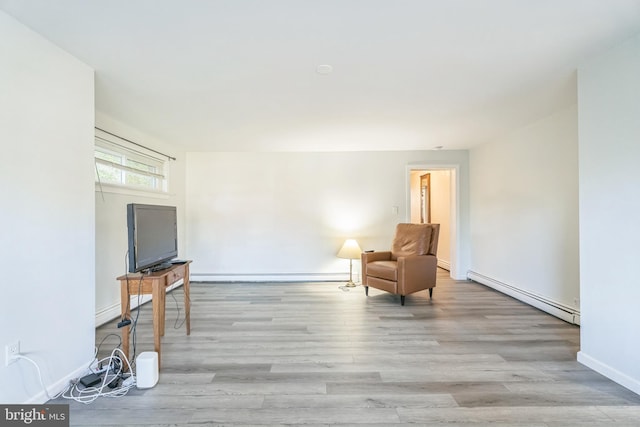 unfurnished room with light wood-type flooring and a baseboard heating unit