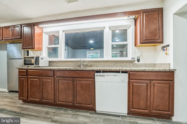 kitchen featuring stainless steel fridge, white dishwasher, and sink