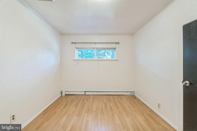 empty room featuring light hardwood / wood-style flooring and a baseboard heating unit