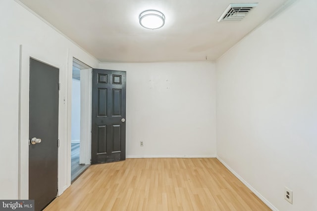 spare room with wood-type flooring and ornamental molding