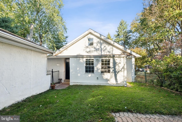 back of property featuring a lawn