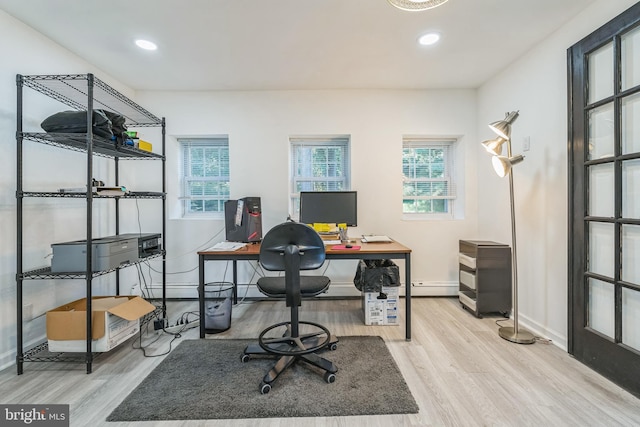 office area with light wood-type flooring and a baseboard heating unit