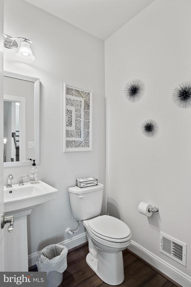 bathroom featuring hardwood / wood-style flooring and toilet