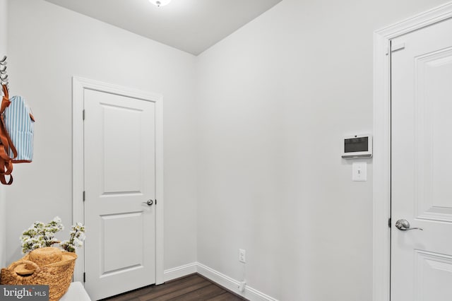 clothes washing area with dark wood-type flooring