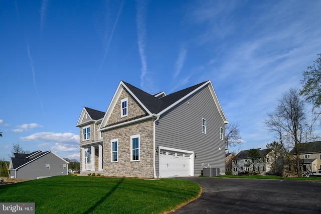 view of side of home with central AC, a garage, and a lawn