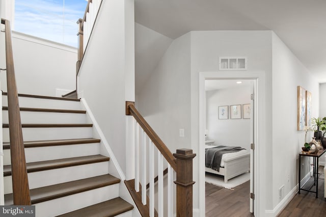 stairs featuring hardwood / wood-style floors