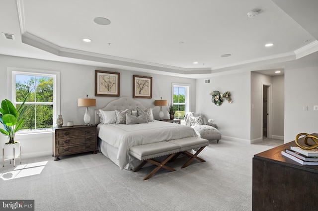 carpeted bedroom featuring a tray ceiling, multiple windows, and crown molding