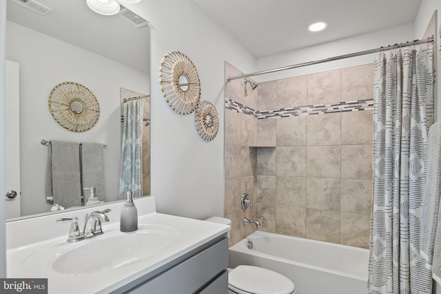 full bathroom with vanity, shower / bath combo, and toilet