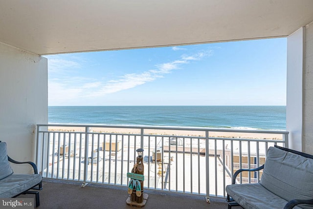 balcony featuring a view of the beach and a water view