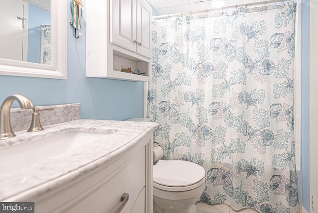 bathroom with vanity, toilet, curtained shower, and a textured ceiling