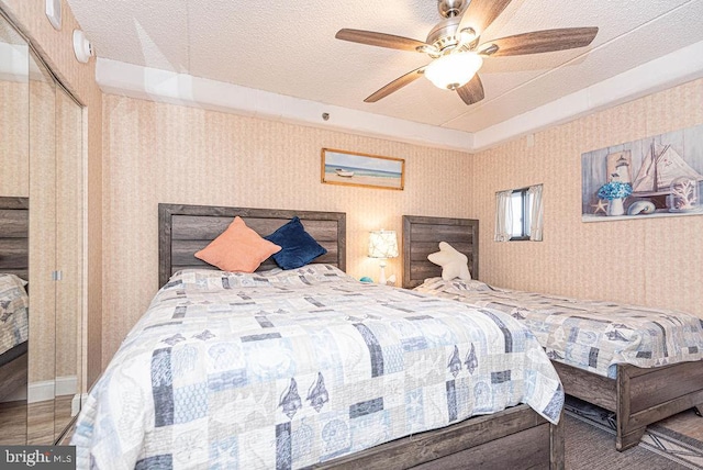 bedroom featuring a closet, a textured ceiling, and ceiling fan