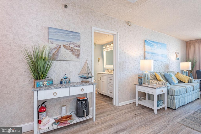 interior space featuring sink, light hardwood / wood-style flooring, and a textured ceiling