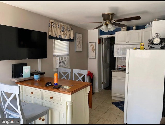 kitchen featuring white cabinetry, wood counters, light tile patterned floors, and white refrigerator