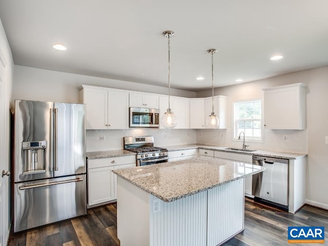 kitchen with a center island, dark hardwood / wood-style floors, hanging light fixtures, white cabinetry, and appliances with stainless steel finishes