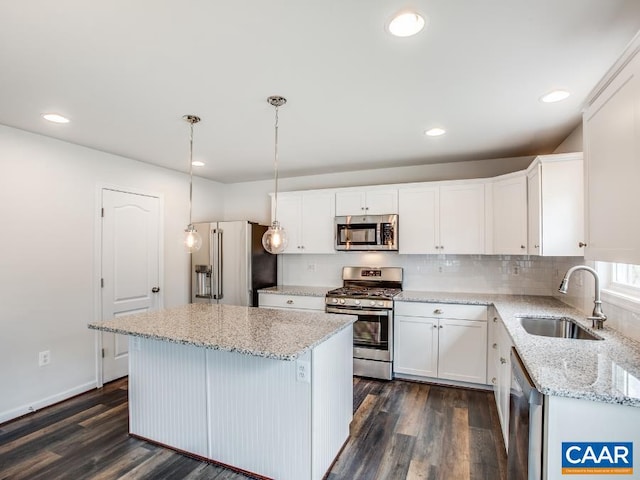 kitchen with white cabinets, stainless steel appliances, pendant lighting, and dark hardwood / wood-style flooring