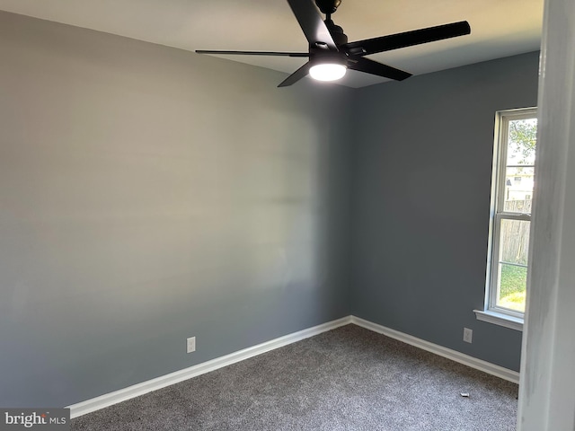 carpeted spare room featuring ceiling fan and plenty of natural light