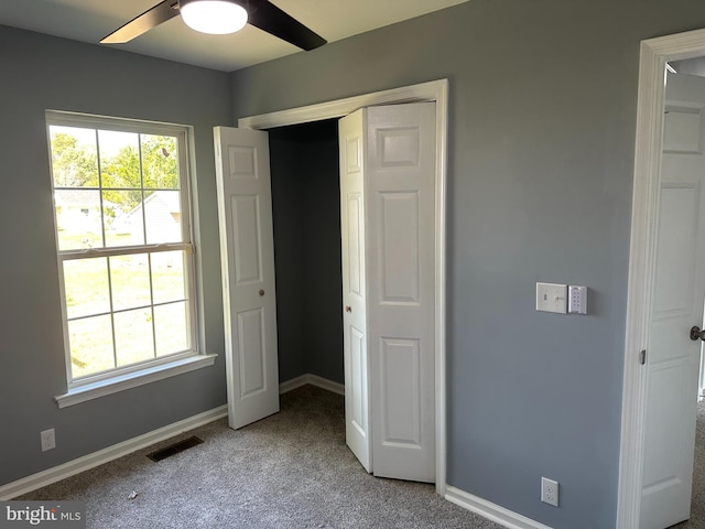 unfurnished bedroom featuring carpet flooring, a closet, and ceiling fan