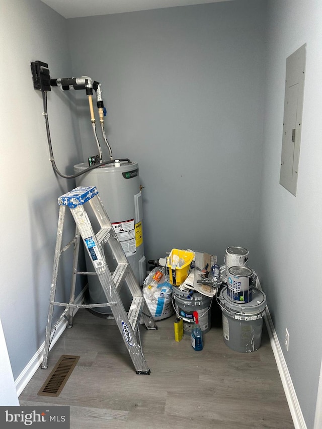 utility room featuring electric panel and water heater