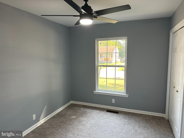 spare room with ceiling fan and carpet