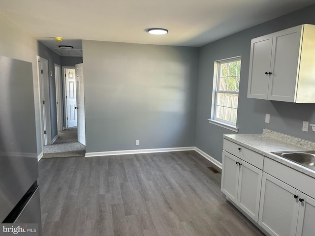 kitchen featuring sink, hardwood / wood-style floors, and white cabinets