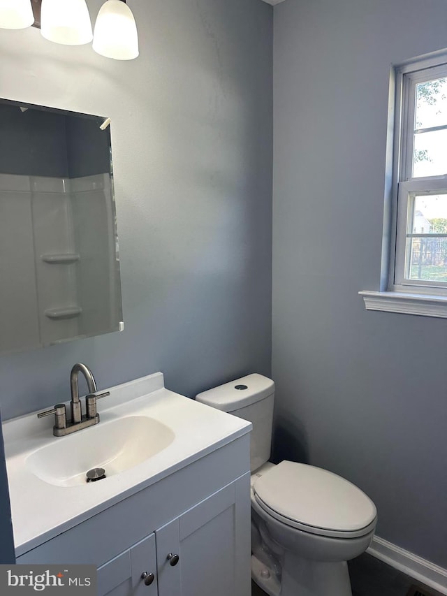 bathroom featuring vanity, a shower, and toilet