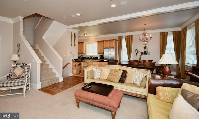 living room featuring a notable chandelier, plenty of natural light, stairs, and ornamental molding