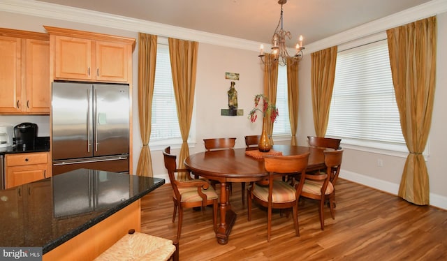 dining room featuring baseboards, light wood-style floors, an inviting chandelier, and ornamental molding