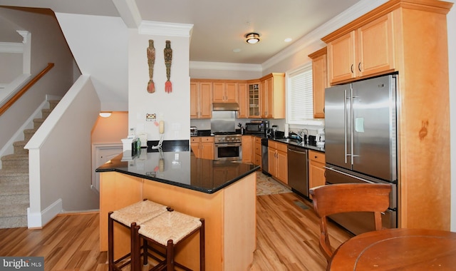 kitchen featuring crown molding, glass insert cabinets, light wood-style floors, and premium appliances