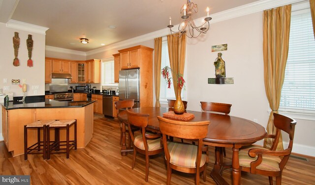 9 134th St Unit 9A, Ocean City, MD 21842 - dining area featuring light wood-style flooring, crown molding, and a chandelier