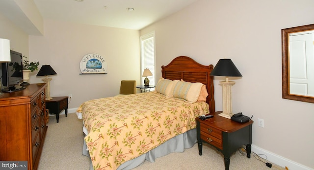 bedroom featuring light colored carpet and baseboards