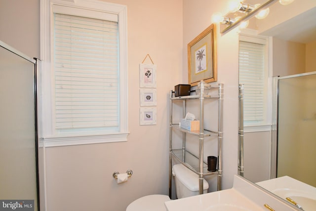 bathroom featuring an enclosed shower, toilet, and vanity